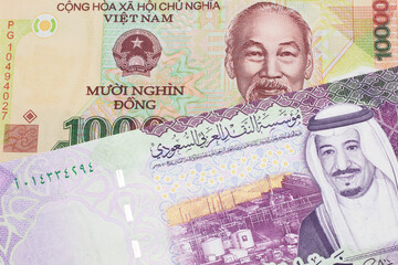 A colorful ten thousand dong note from Vietnam close up in macro with A colorful, five Saudi riyal bank note