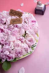 plate of pink fresh fragrance roses  with ring around double pink  background. romantic and beauty concept