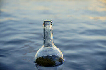 glass bottle floats adrift in water