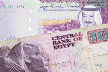 A ten Egyptian pound bill with A colorful five riyal note from Saudi Arabia close up in macro