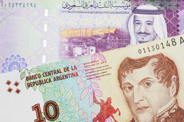 A ten peso bill from Argentina, close up in macro with a colorful five riyal bank note from Saudi Arabia