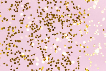 Golden shiny stars confetti scattered on a pastel purple background. Magic holiday backdrop.