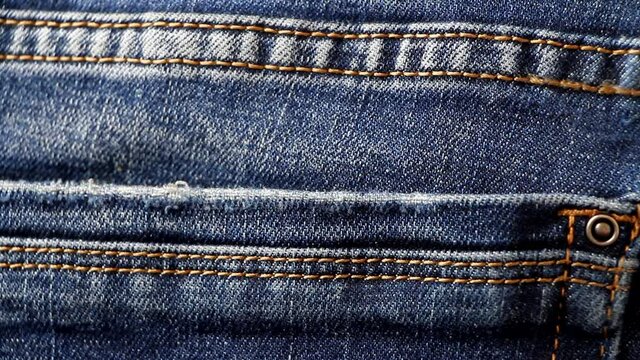 Pickpocketing using tweezers. Stealing dollars from pants. Professional thief takes money from the back pocket of jeans. 