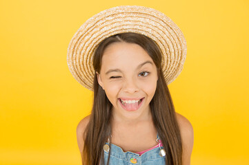 funny beauty. holiday joy and activity. beauty. long-awaited summer vacation. happy childhood. winking little girl wear straw hat. beach fashion for kids. small child on yellow background
