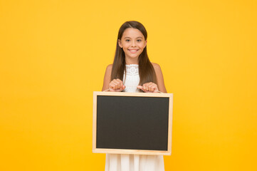 Read this. Something you need to know. Happy smiling girl hold blackboard. Small kid with blank blackboard. Advertisement promotion copy space. Chalkboard for information. Blank blackboard