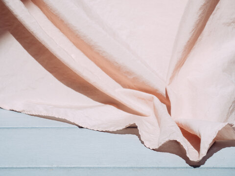 close up of a draped rosa silk fabric on light grey background