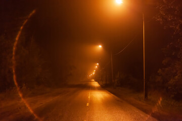 night desert two-lane road in the fog, along the road shine lanterns