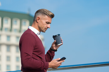 Time for break. Handsome man hold takeaway cup and smartphone. Morning break. Coffee break. Rest break during working day. Addicted by mobile smart phone. Enjoy coffee wherever you are