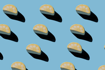 Pattern of tasty marshmallows with hard shadows on a light blue background.