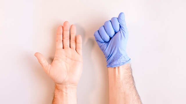 Image 5 of a sequence of images in which a man's hands taking off blue disposable gloves medical. Top view. Selective focus
