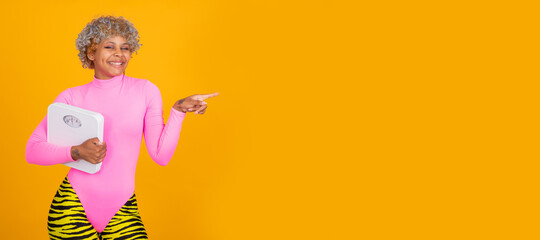 young girl with weighing scale pointing isolated on color background