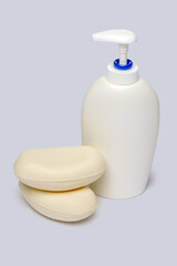piece of soap and bottle of liquid soap over light grey backgound with clipping path