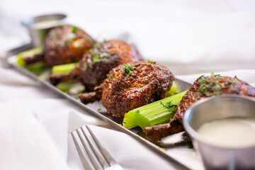 A view of an appetizer plate of chicken lollipops, in a restaurant or kitchen setting.