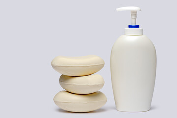 piece of soap and bottle of liquid soap over light grey backgound with clipping path