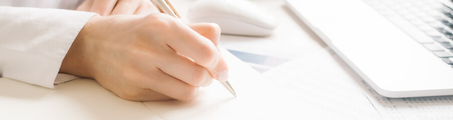 The woman's hands are writing note and coffee cup in open spect and light gold in morning. High quality photo