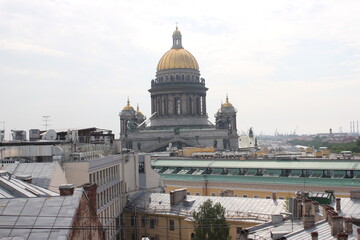 Fototapeta na wymiar Saint-Petersburg, Russia - 10.06.20. Cityscape panorama of old central city part, view from a roof. Famous rooftops of St. Petersburg with Saint Isaac's Cathedralat the background.