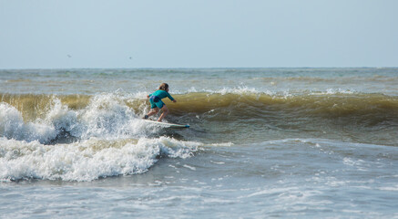 Panorama of young boy surfing on the Atlantic Ocean.