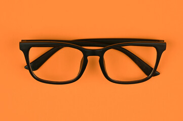black glasses on an orange background