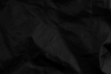 Abstract black synthetic material with wrinkles and wrinkled folds
