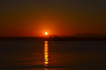 Naklejka premium Canakkale with a sunrise and a steamer, morning hours, red colors, sunrise, orange, red, yellow colors 