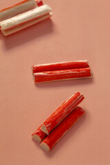 Fresh frozen foods from processed fish protein surimi on a pink background