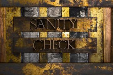 Sanity Check text formed with real authentic typeset letters on vintage textured silver grunge copper and gold background