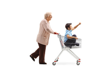Grandmother pushing a shopping cart with a happy boy inside