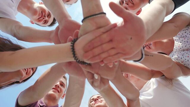 Friendly friends clasp hands as a sign of strong friendship and teamwork.