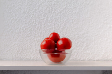 Red tomatoes in a transparent bowl