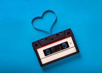 Love music concept retro audio tape cassette isolated on blue background, pop art design, close up