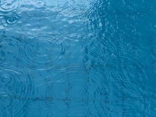 Blue pool water with with raining.Abstract background of water.