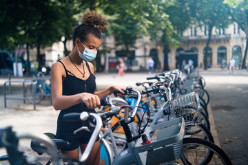 Obraz premium Young beautiful woman renting a bicycle in the city