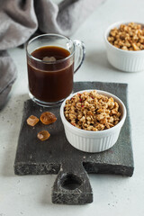 Homemade granola in a white bowl with caramel and a Cup of coffee. The concept of a healthy Breakfast.