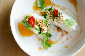 Spring rolls served with shrimp on a white plate. Cooking. National cuisine