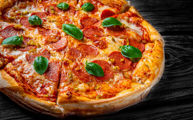 Pepperoni Pizza with Mozzarella cheese, salami, Tomato sauce, pepper, Spices and Fresh basil. Italian pizza on wooden table background