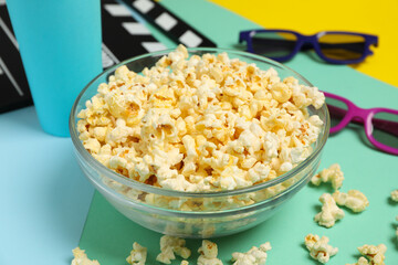 Composition with bowl of popcorn on multicolor background