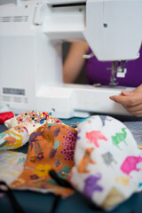 Woman sewing homemade fashion cotton fabric masks at home