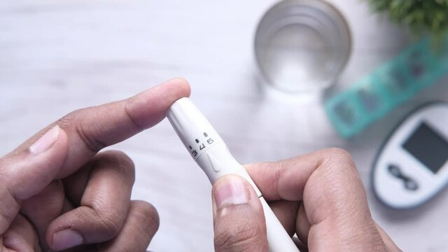 young man doing blood sugar test at home.