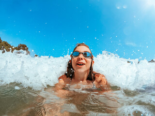 Girl getting splashed by the sea wave