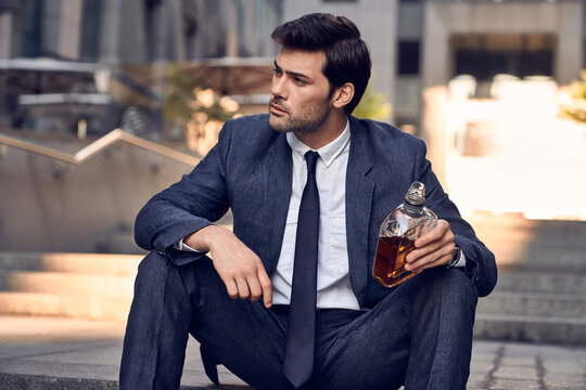 Depressed Businessman Drinking Whiskey From A Bottle. The Man Was Fired