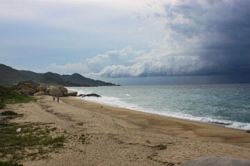 Caribbean sea with white sand beach surrounded by tropical forest in Tayrona National Park in Cabo San Juan del Guia, Colombia.