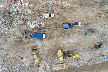 Garbage pile in trash dump or landfill. Dump trucks and excavators unloading waste. 