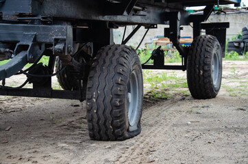 Fototapeta na wymiar Old rusty tractor's flat back tire. industrial
