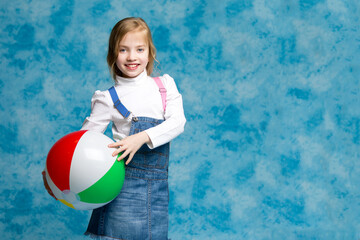 Little girl is playing with a ball.The concept of children's sports, summer outdoor recreation.