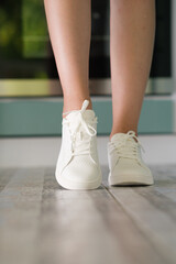 Fototapeta na wymiar White women's sneakers dressed by a girl