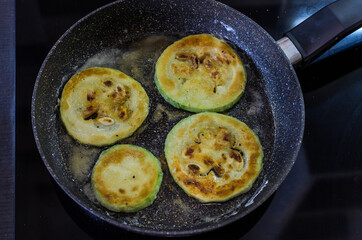 Cook fries zucchini in a pan on an induction cooker