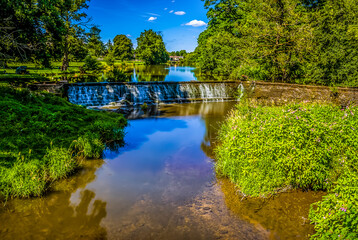 Fototapeta premium A long exposure view of two weirs across the River Alne at Wootton Wawen, Warwickshire, UK