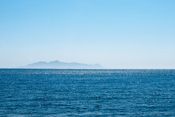 sea on the horizon island against a clear blue sky