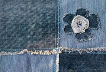 Old denim jeans texture or background made from different colored jeans peaces.