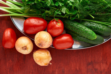 healthy food - fresh vegetables and greens on a wooden background, greens, onion and tomatoes